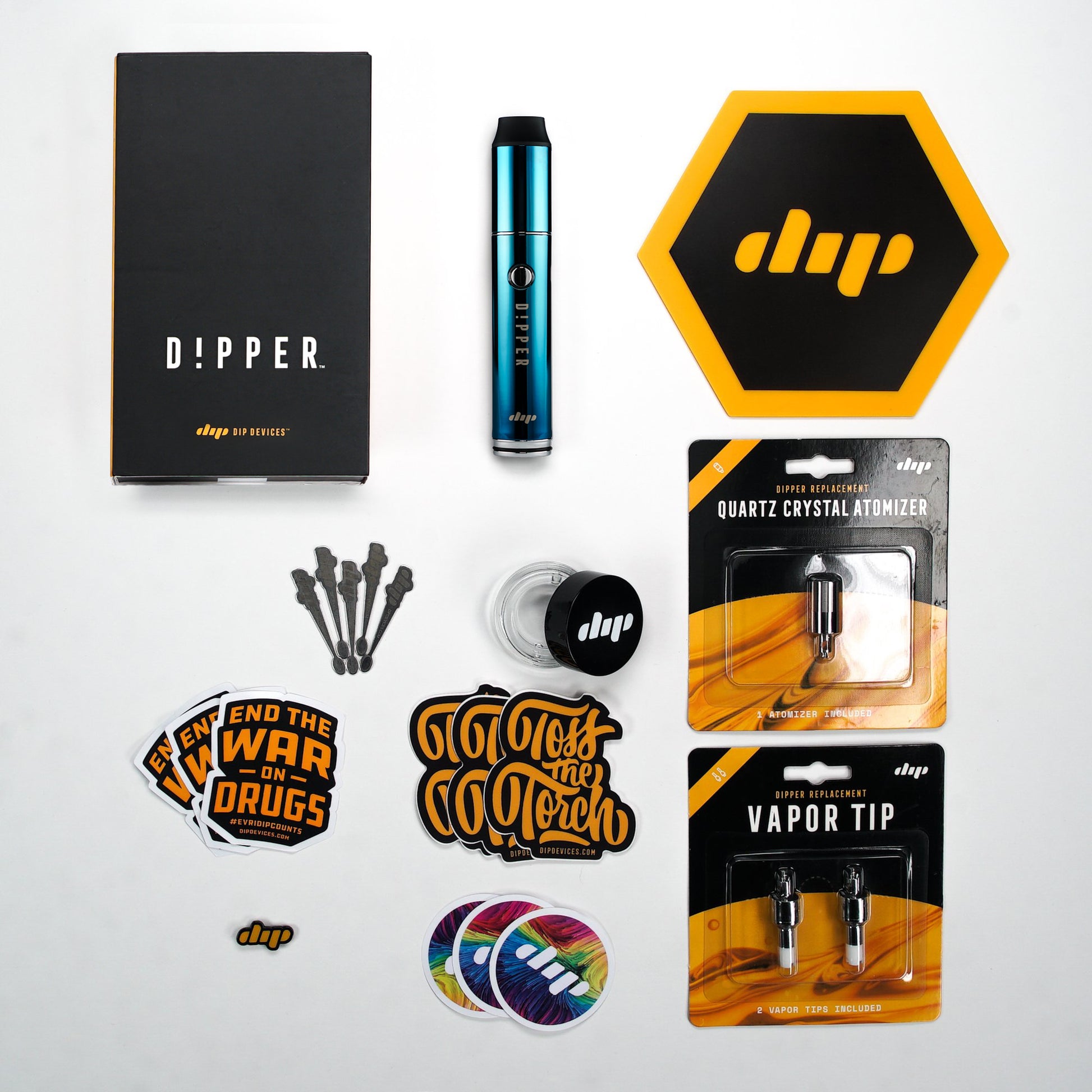 Dipper by Dip Devices bundle featuring a Dipper pen, replacement atomizers (Vapor Tip 2pk and Quartz Crystal Attachment), a dip glass container, Dip mat, lapel pin, 5 dab tools, and a variety of Dip Device stickers.