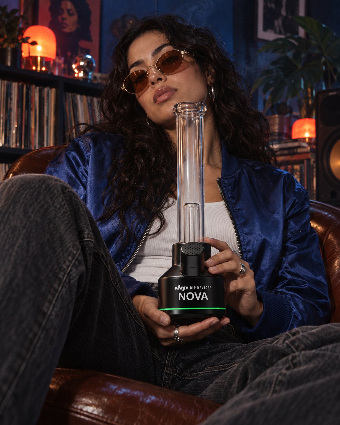 Nova electric bong held in one hand in an armchair, showing its tabletop size and one-handed use