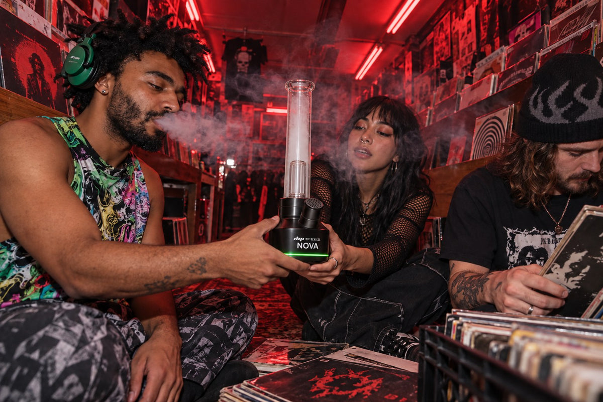 Friends sharing a Nova electric bong in a record shop — no lighter or torch being passed around
